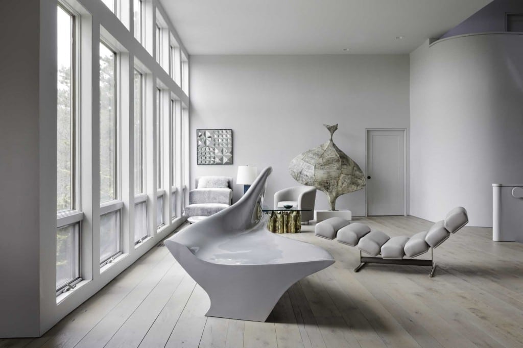 A Vladimir Kagan Omnibus high-low seat and a Verner Panton mirror sculpture occupy a corner of the living room of this Southampton home, which doubles as a design lab for Todd and Lauren Merrill. The glass, brass and steel of the coffee table, by Silas Seandel, complements the sculpture "Onion" by Paul Evans. (Credit: Courtesy of The Monacelli Press / Fran Parente)